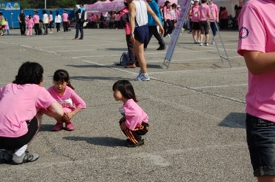 엄마와 아이 두 명이 쪼그리고 앉은 사진
