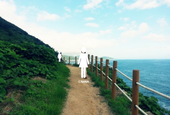 바다가 보이는 남해 바래길에 서 있는 두 친구의 모습.