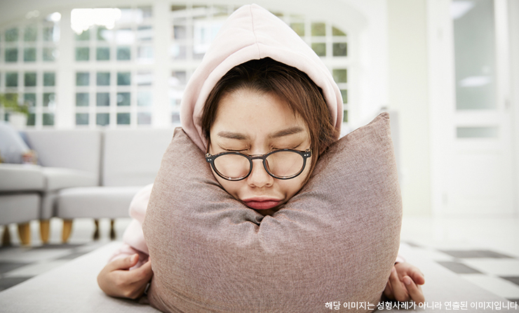 얼굴을 찌푸리고 있는 여자